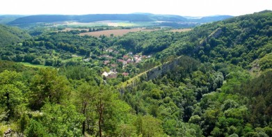 Vyhlídka do údolí říčky Loděnice v Českém krasu, dole obec Hostim. Říčka si prorazila cestu skálou, která leží kolmo k jejímu toku.