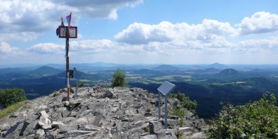 Vrcholek Klíče (759 m) v Lužických horách, pohled směrem k východu. Vlevo u tyče na horizontu Ještěd, vpravo na horizontu vystupuje Ralsko.
